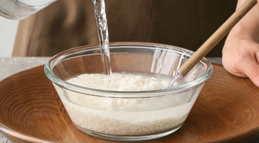 Photographie d'une personne utilisant de l'eau pour cuire son riz.